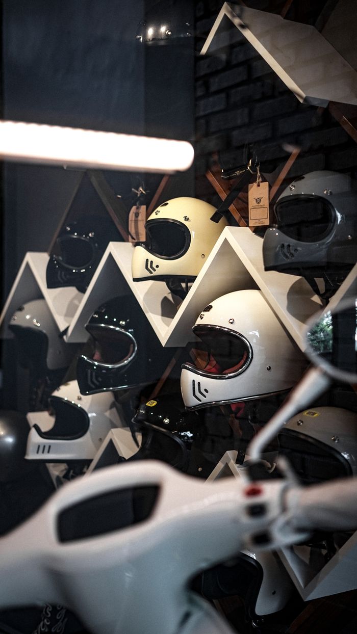 services-05 A collection of motorcycle helmets displayed on geometric shelves in a modern store setting.