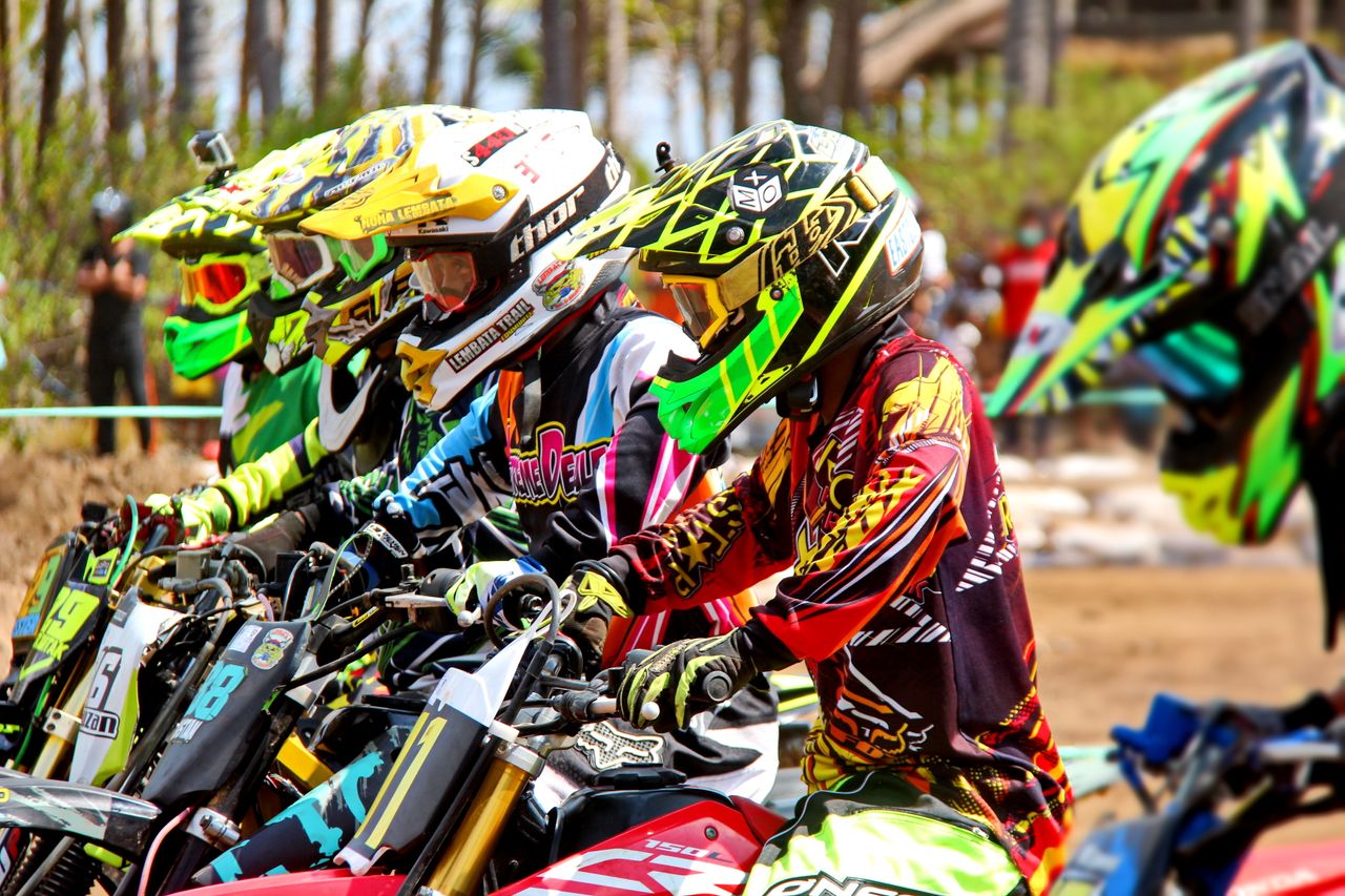 why-choose-us-02 Motocross riders in vibrant gear prepare for a thrilling race outdoors.